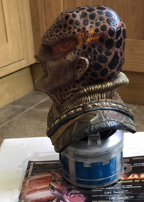 Decorative helmet with leopard print design on top of a cylindrical object with blue accents, placed on a surface.