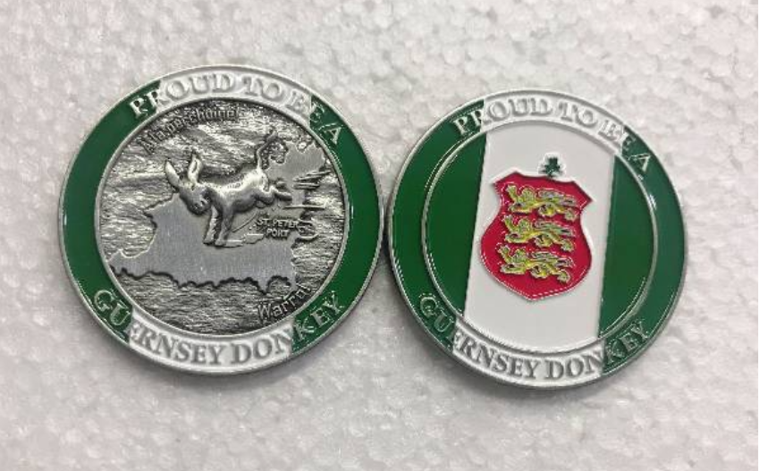 Two coins featuring Guernsey donkey designs on a light gray background