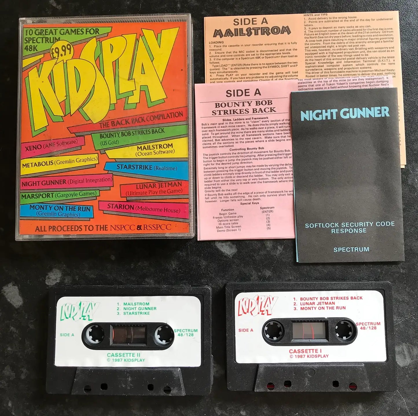 Collection of vintage computer software packages and tapes on a dark surface